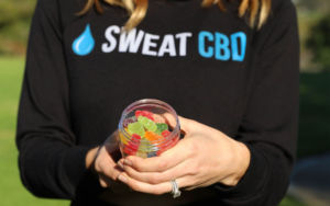 Woman holding sweat cbd gummy bears